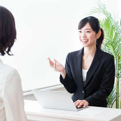 相談者に資料を見せながら説明する女性カウンセラー